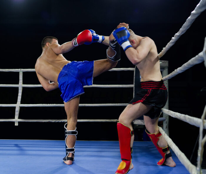 Kickboxing rivals unleash powerful leg strikes in a thrilling match. Two skilled kickboxers engage in a fierce and technical exchange of kicks in a captivating display of athleticism and combat prowess.